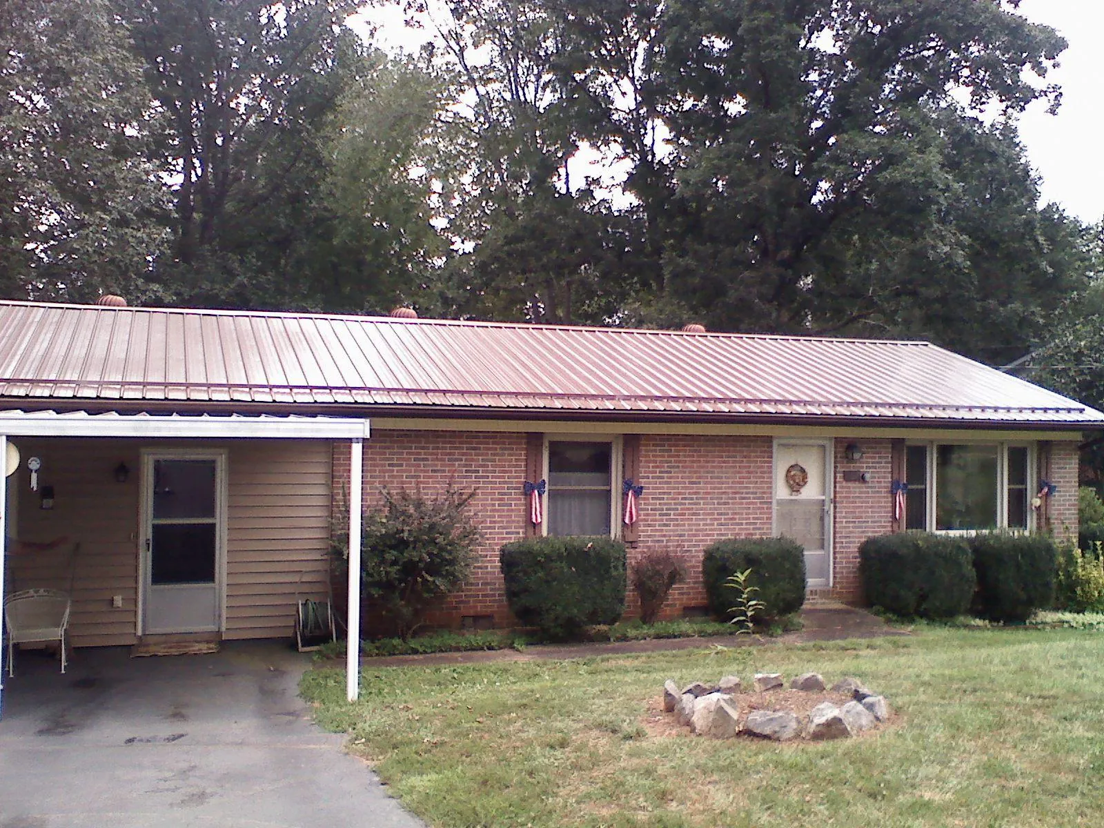 Bronze metal roof and carport on a brick ranch home — Roof Repair work by our crew in Alexander